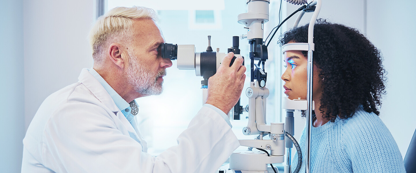 Ein Arzt untersucht das Auge einer Patientin