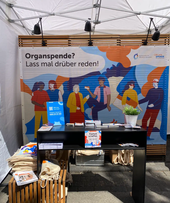 Das Bild zeigt einen Stand des BIÖG Organspende mit Plakaten und Goodies.